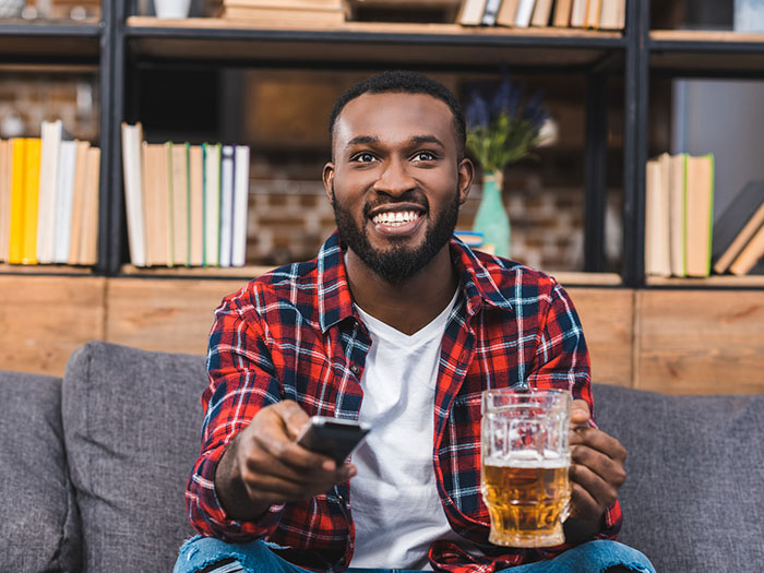 Man drinking beer at home on couch