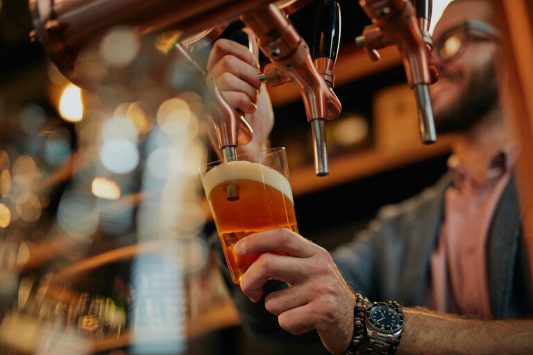 Man pouring beer into glass in bar