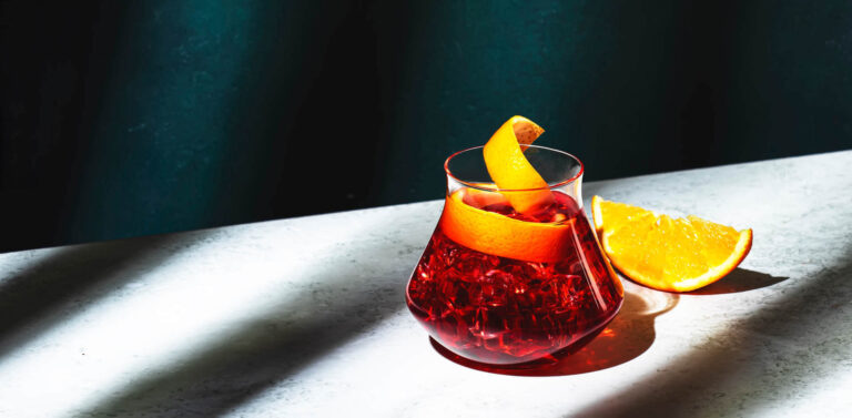 Negroni with ice and orange in glass on table
