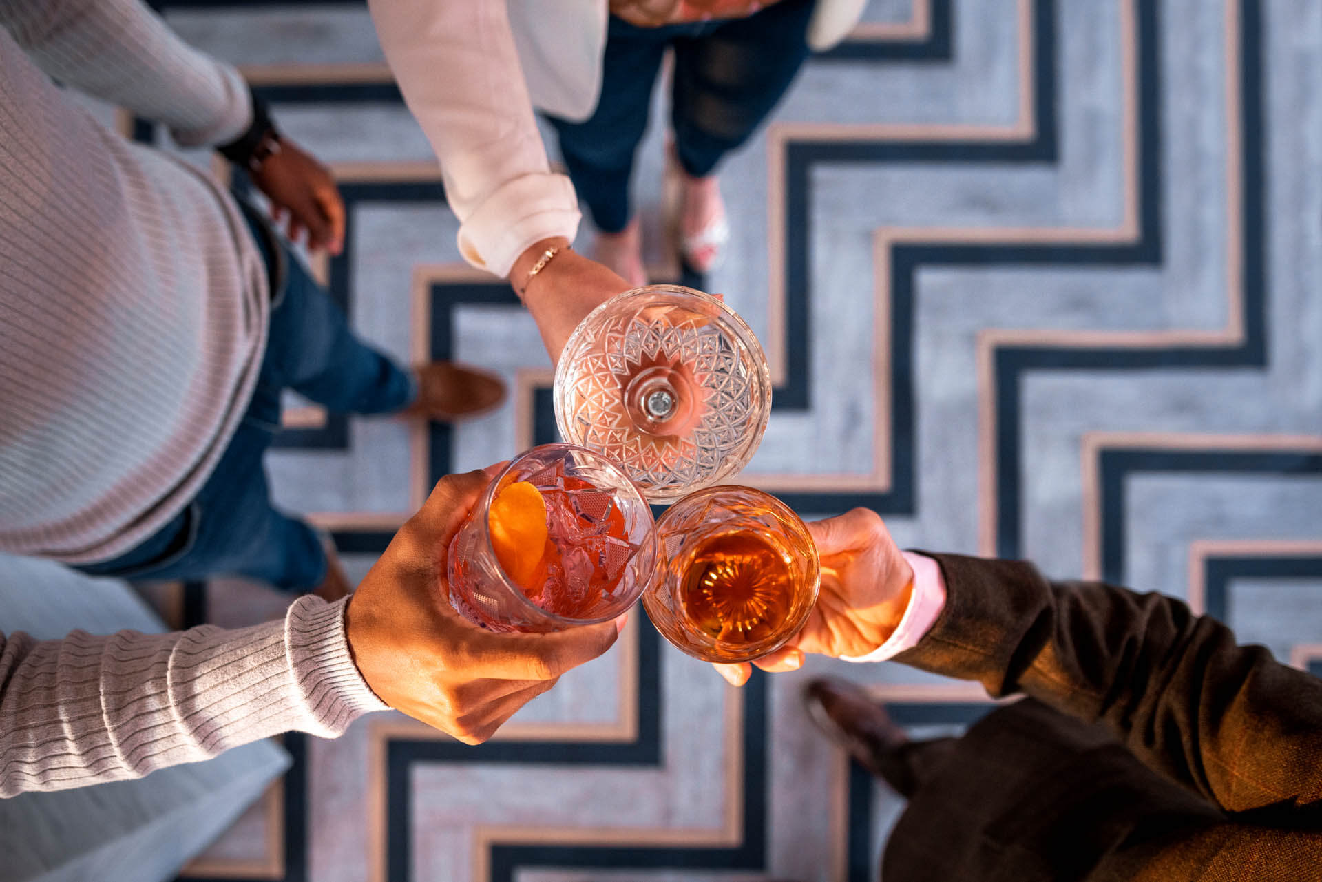 Three people toasting with cocktails