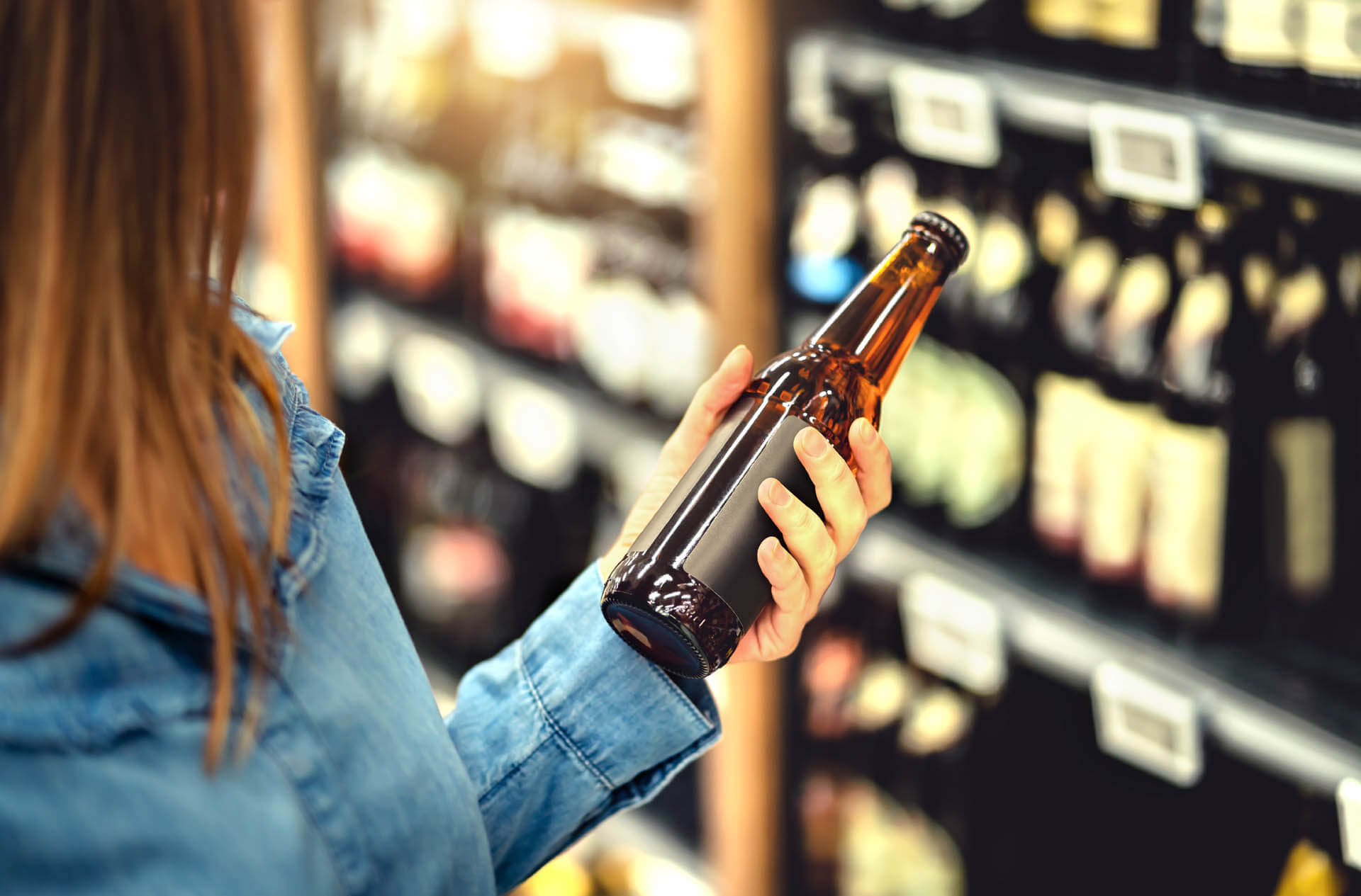 Woman in shop reading beer label